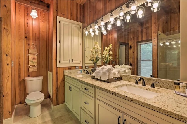 bathroom with tile patterned flooring, wooden walls, vanity, and toilet