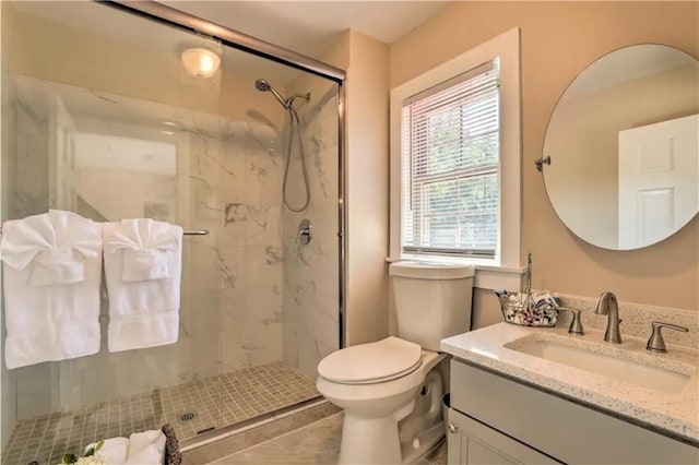 bathroom featuring vanity, walk in shower, and toilet