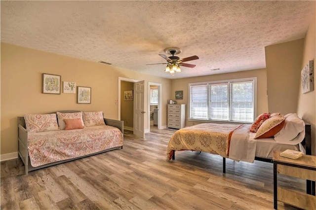 bedroom with a textured ceiling, ceiling fan, and hardwood / wood-style flooring