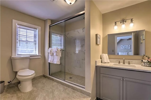 bathroom featuring toilet, a shower with door, and vanity