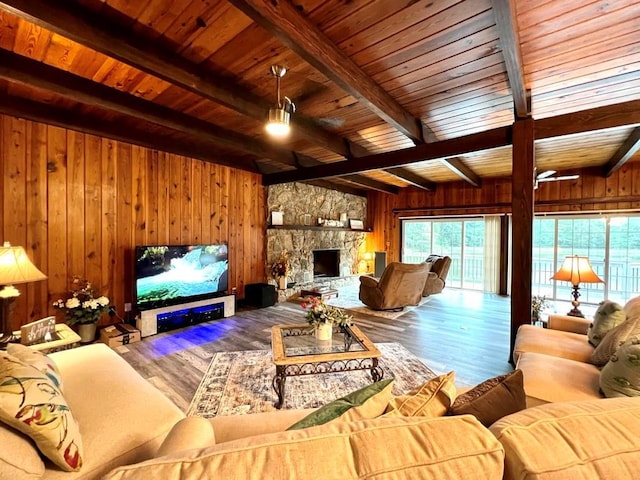 living room with wood walls, wood ceiling, beam ceiling, a fireplace, and wood-type flooring