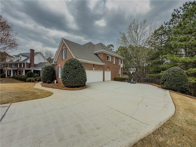 view of property exterior featuring brick siding, concrete driveway, an attached garage, and a lawn