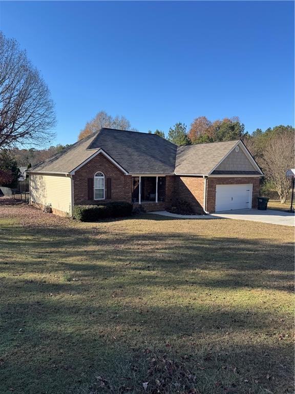 single story home with a garage and a front lawn