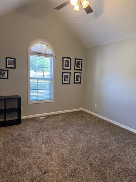 carpeted spare room featuring high vaulted ceiling and ceiling fan