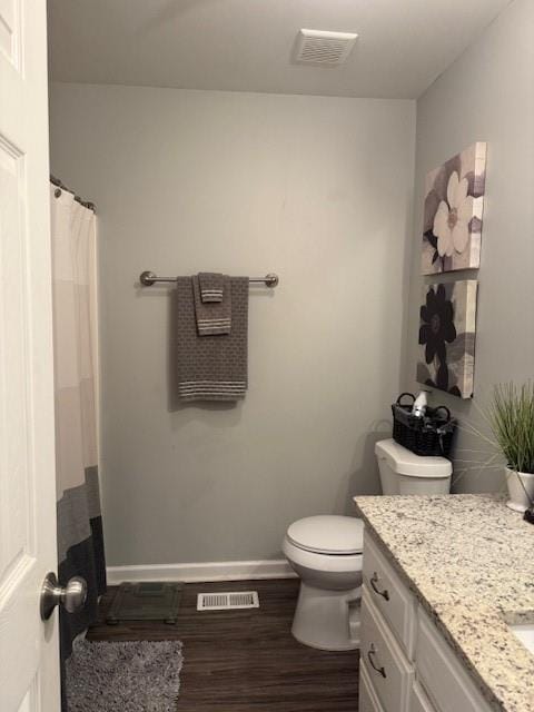 bathroom featuring vanity, toilet, and hardwood / wood-style floors