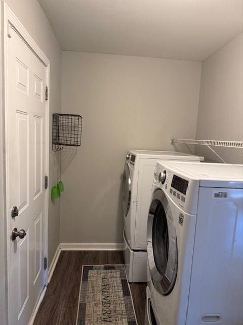 laundry area featuring separate washer and dryer and dark hardwood / wood-style flooring