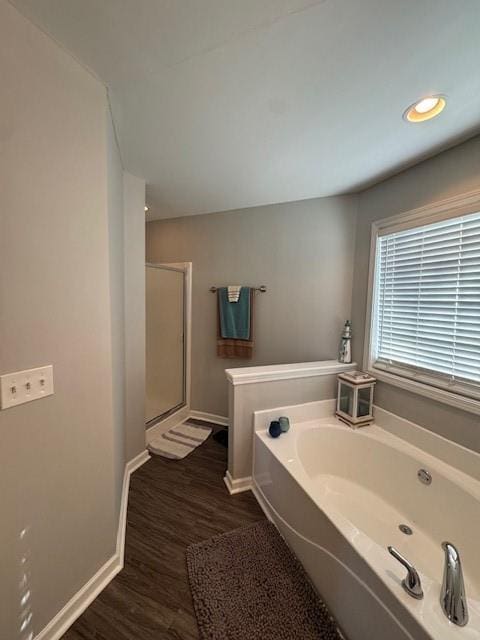 bathroom with independent shower and bath and hardwood / wood-style floors