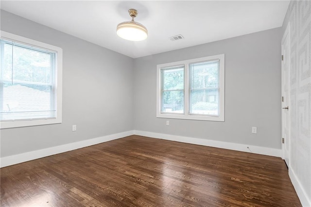 unfurnished room with plenty of natural light and dark hardwood / wood-style floors