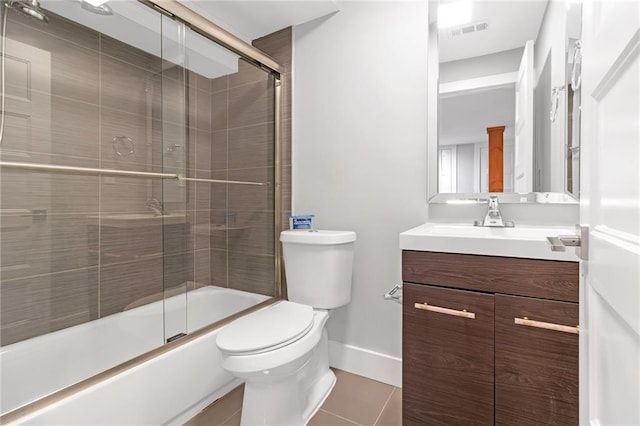 full bathroom featuring tile patterned floors, vanity, toilet, and bath / shower combo with glass door