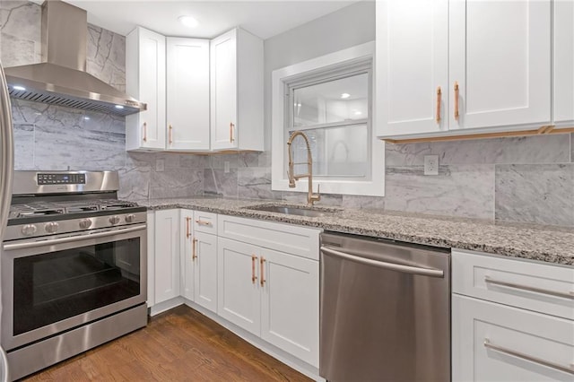 kitchen featuring white cabinets, stainless steel appliances, wall chimney exhaust hood, and sink