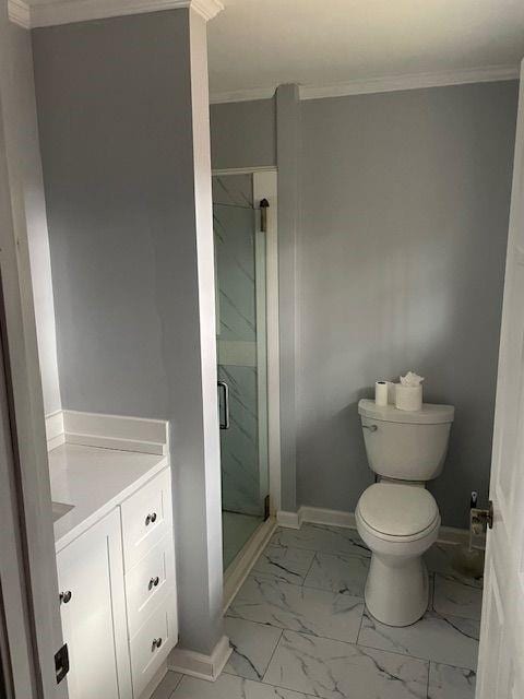 bathroom with vanity, toilet, an enclosed shower, and ornamental molding