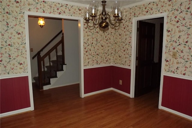 unfurnished dining area with a notable chandelier, dark hardwood / wood-style flooring, and ornamental molding