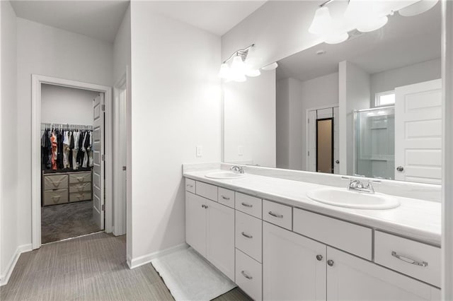 187 Lyndhurst Dr, Bethlehem, GA 30620 - full bathroom featuring double vanity, a walk in closet, a shower stall, and baseboards