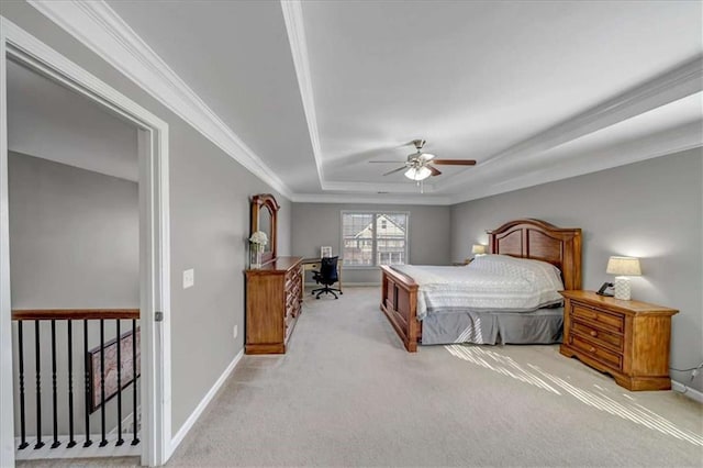 carpeted bedroom featuring ceiling fan, ornamental molding, and a raised ceiling