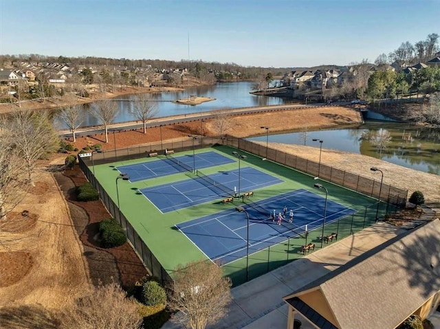 view of tennis court featuring a water view