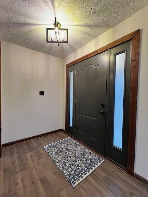 foyer entrance with hardwood / wood-style flooring, a textured ceiling, and a chandelier