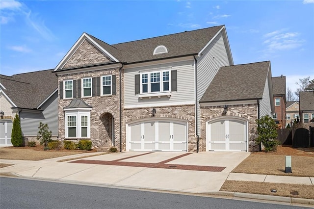 view of front of property featuring brick siding, driveway, and roof with shingles