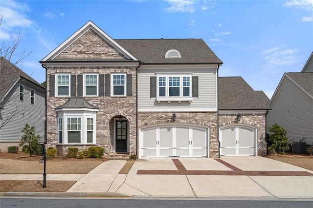 view of front of house with concrete driveway, central air condition unit, and brick siding