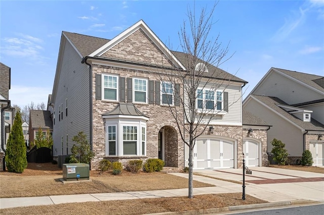 view of front of property with brick siding, cooling unit, driveway, and a garage