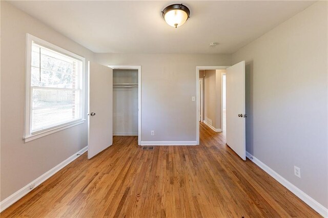 unfurnished bedroom with hardwood / wood-style flooring and a closet