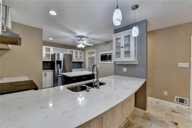 kitchen featuring tasteful backsplash, stainless steel appliances, sink, pendant lighting, and white cabinetry