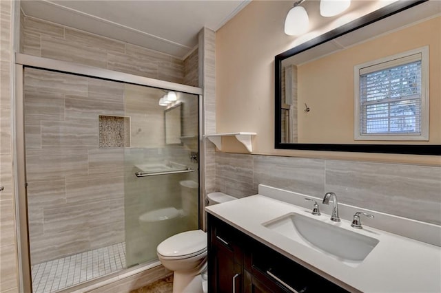 bathroom with walk in shower, vanity, tile walls, and toilet