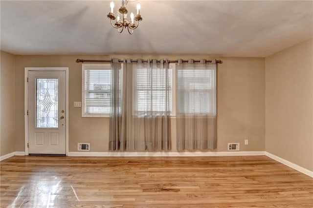 entrance foyer with hardwood / wood-style flooring and an inviting chandelier