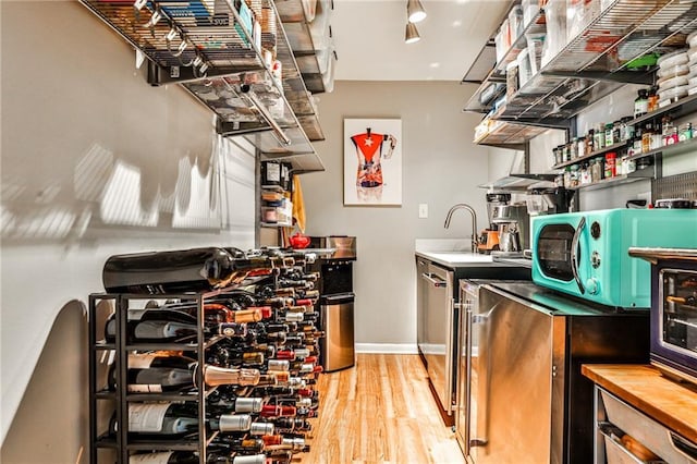 wine cellar with wood-type flooring and wet bar