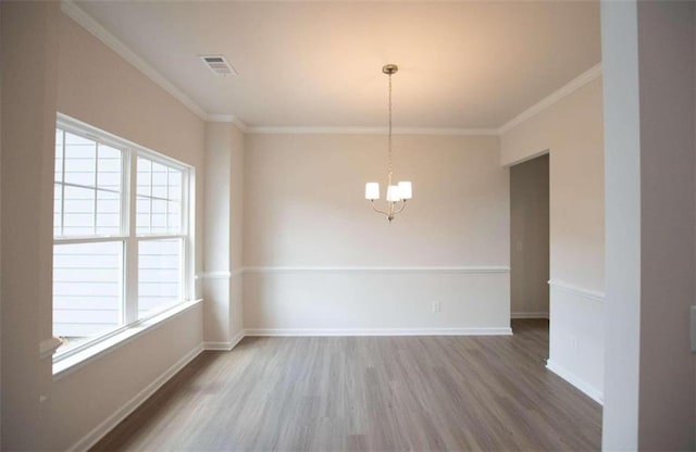 unfurnished room featuring ornamental molding, hardwood / wood-style floors, and a chandelier