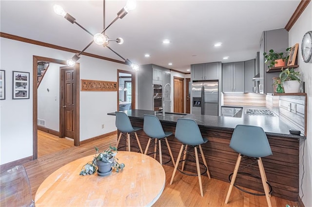 kitchen with open shelves, ornamental molding, light wood-style floors, gray cabinets, and stainless steel appliances