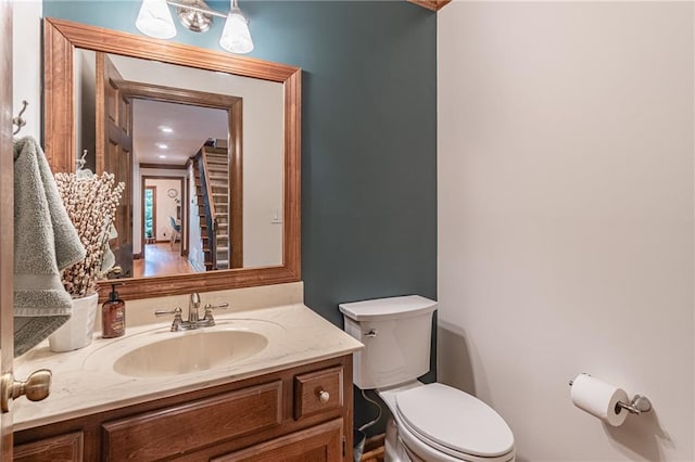 half bathroom featuring vanity and toilet