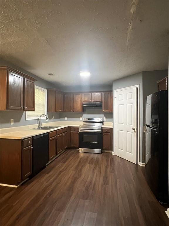 kitchen featuring black appliances, exhaust hood, a sink, dark wood-type flooring, and light countertops