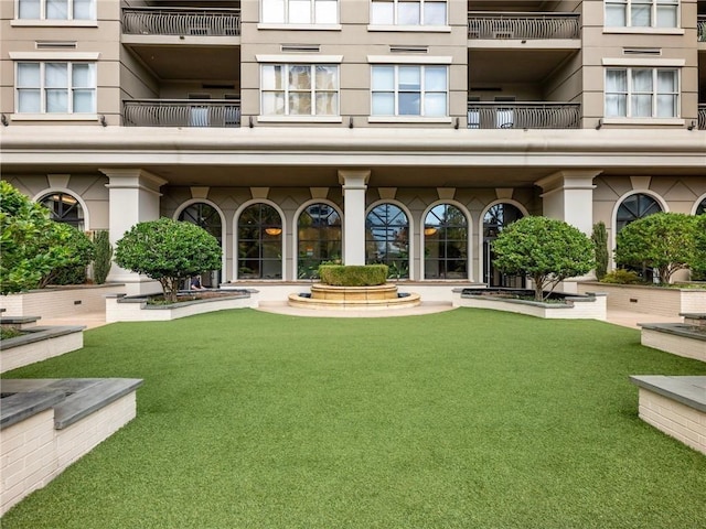3334 Peachtree Rd NE Unit 608, Atlanta, GA 30326 - view of exterior entry featuring stucco siding, a balcony, and a lawn
