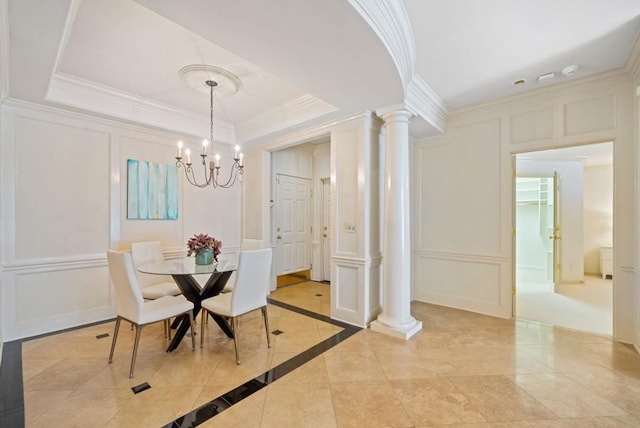 living room with an inviting chandelier, ornamental molding, and ornate columns