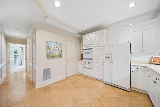 kitchen featuring sink, crown molding, white dishwasher, white cabinets, and light tile patterned flooring