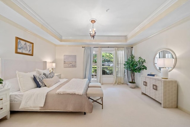 carpeted bedroom with a raised ceiling, crown molding, a chandelier, and ensuite bath