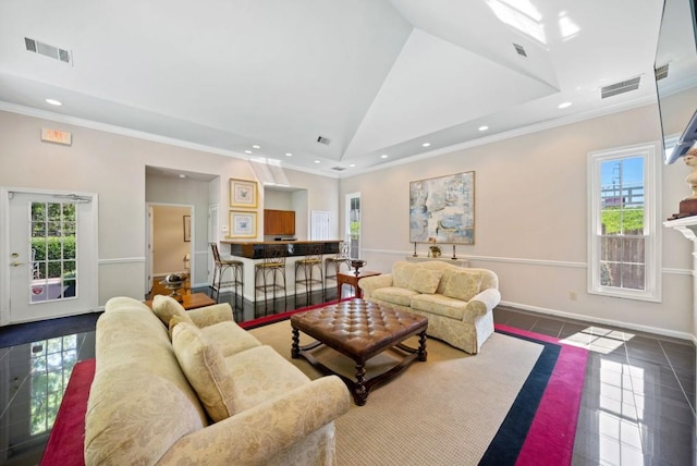 living room featuring ornamental molding, a healthy amount of sunlight, and a tiled fireplace