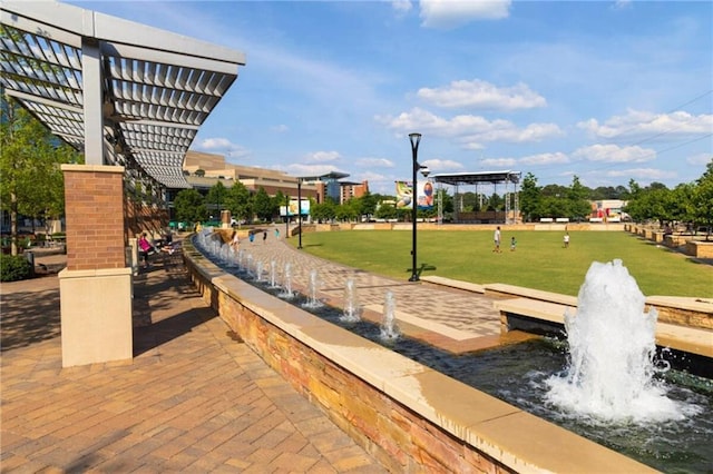 view of property's community featuring a pergola and a lawn
