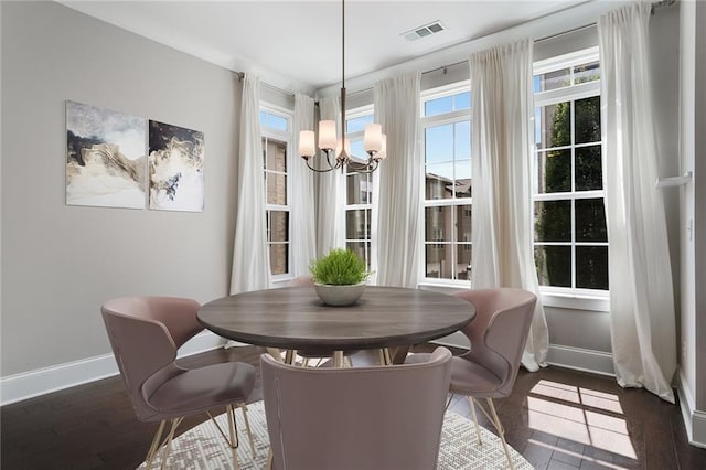 dining space featuring an inviting chandelier and dark wood-type flooring