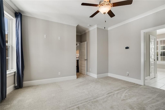 unfurnished room featuring ceiling fan, light colored carpet, and crown molding