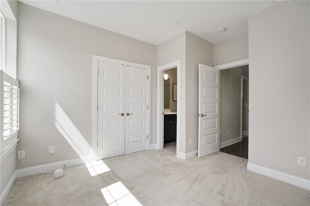 unfurnished bedroom featuring light colored carpet and a closet