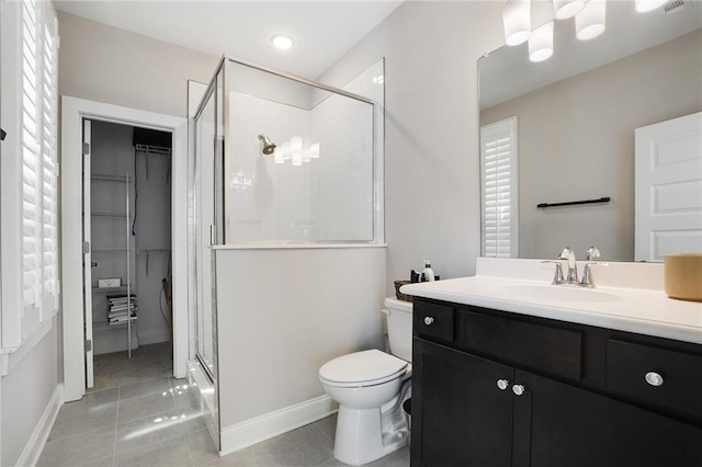 bathroom with tile patterned flooring, walk in shower, vanity, and toilet