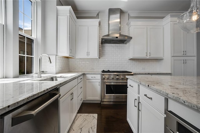 kitchen with white cabinets, sink, backsplash, wall chimney range hood, and stainless steel appliances