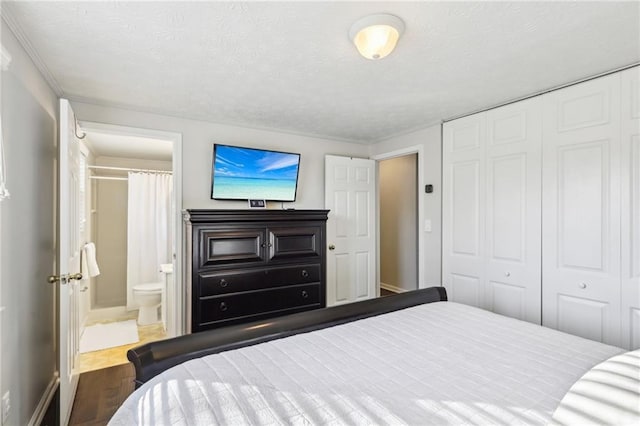 10475 Willow Meadow Cir, Alpharetta, GA 30022 - bedroom with a closet, connected bathroom, wood finished floors, and a textured ceiling