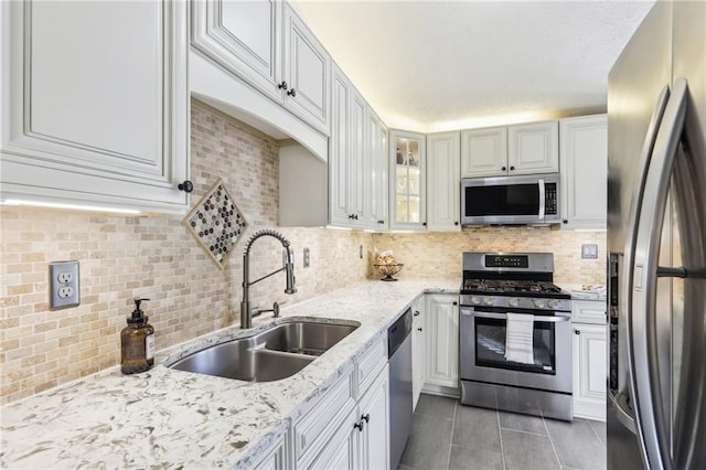 10475 Willow Meadow Cir, Alpharetta, GA 30022 - kitchen featuring appliances with stainless steel finishes, light tile patterned floors, decorative backsplash, and light stone countertops
