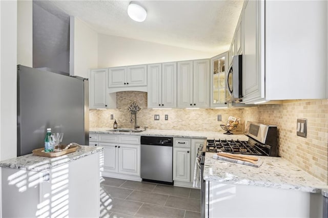 10475 Willow Meadow Cir, Alpharetta, GA 30022 - kitchen featuring stainless steel appliances, lofted ceiling, light tile patterned floors, decorative backsplash, and light stone countertops