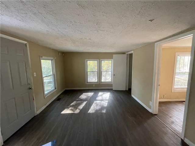 foyer entrance featuring dark wood-type flooring and a textured ceiling