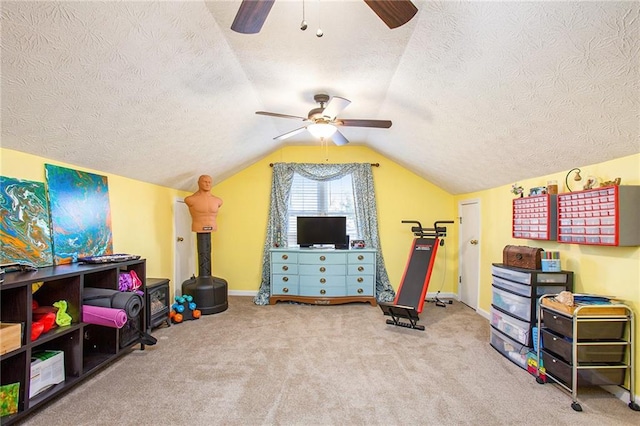 rec room with ceiling fan, lofted ceiling, carpet flooring, and a textured ceiling