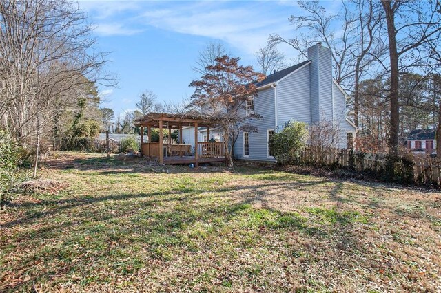 back of property with a wooden deck, a yard, and a pergola