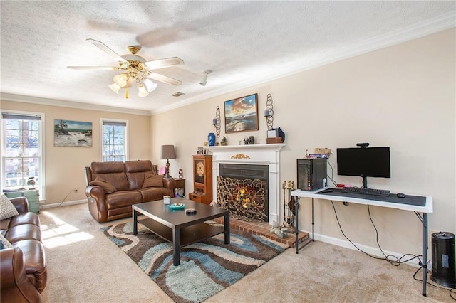 carpeted living room with ornamental molding, a brick fireplace, ceiling fan, and a textured ceiling